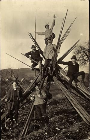 Foto Ak, sechs Wanderer mit Rucksäcken sind auf Holzstäbe geklettert