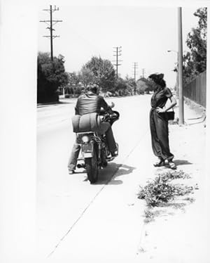 Foto Lilo Korenjak, Filmszene, Frau am Straßenrand und Mann auf Motorrad im Gespräch