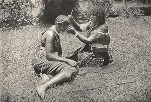 Bild des Verkufers fr Zulu women at their toilet - The illustration shows one Zulu woman assisting her neighbour to braid her hair. Note the great variety of ornaments, and especially the girdles, armlets and anklets. The cicatrization which appears on the arm is a common methods of ornamentation amongst African natives, and is usually carried out in youth zum Verkauf von Antiqua Print Gallery