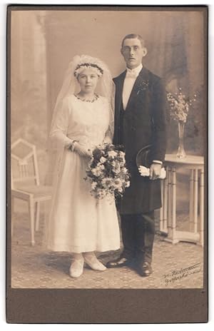 Seller image for Fotografie unbekannter Fotograf und Ort, Portrait junges Ehepaar im Hochzeitskleid und Anzug mit Chapeau Claque for sale by Bartko-Reher