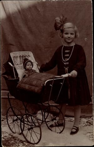 Foto Ansichtskarte / Postkarte Mädchen im Kleid mit Schleife im Haar, Puppenwagen