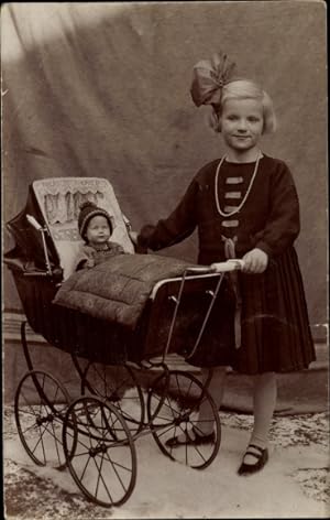 Foto Ansichtskarte / Postkarte Mädchen im Kleid mit Schleife im Haar, Puppenwagen