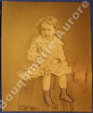 Bild des Verkufers fr Photographie d'un jeune enfant en robe assis sur une sellette. zum Verkauf von Bouquinerie Aurore (SLAM-ILAB)