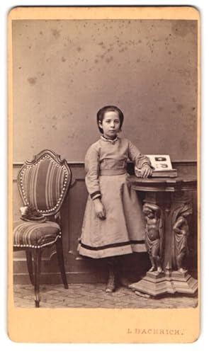 Bild des Verkufers fr Fotografie L. Bachrich, Wien, Ferdinandsstr. 17, Portrait kleines Mdchen im grauen Kleid mit aufgeschlagenene Fotoalbum zum Verkauf von Bartko-Reher