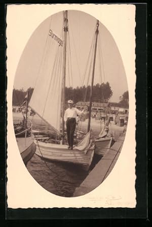 Ansichtskarte Skipper auf seinem Segelboot Sturmvogel am Anlegestag am Strand