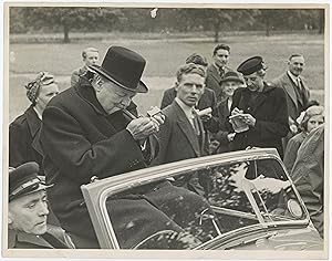 An original Second World War press photograph of Prime Minister Winston S. Churchill lighting a c...