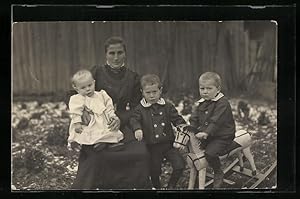Foto-Ansichtskarte Mutter mit Kindern und Schaukelpferd im Winter