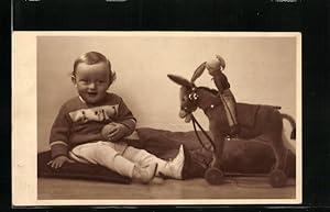 Foto-Ansichtskarte Kleiner Junge mit Spielzeugesel auf Rädern