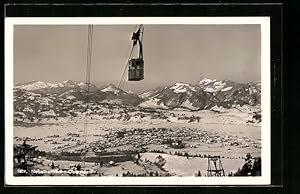 Ansichtskarte Oberstdorf, Nebelhornbahn schwebt über dem verschneiten Ort