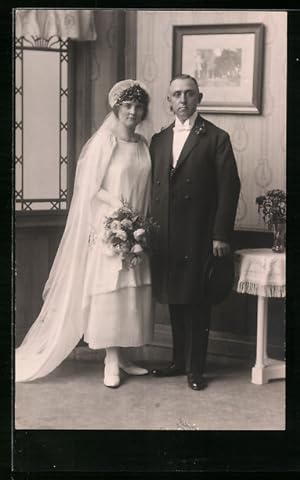 Seller image for Foto-Ansichtskarte Junges Brautpaar im Fotostudio, sie mit Blumenstrauss, er mit Chapeau Claque for sale by Bartko-Reher