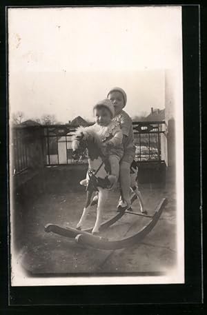 Foto-Ansichtskarte 2 Geschwister sitzen auf einem Schaukelpferd