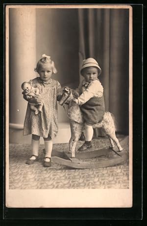 Foto-Ansichtskarte Zwei Kinder mit Puppe und Schaukelpferd