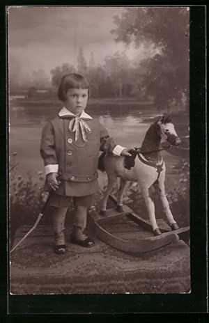 Foto-Ansichtskarte Mädchen mit Prinz Eisenherz-Frisur und ihrem Schaukelpferd