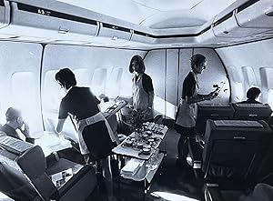 Imagen del vendedor de 1970s Glossy Black and White Photo of Flight Attendants Serving a Meal to Lufthansa 747 First Class Passengers a la venta por 32.1  Rare Books + Ephemera, IOBA, ESA