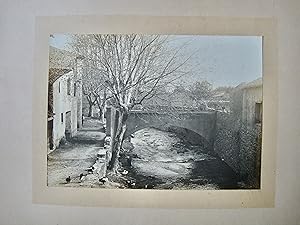 Vue d'un village, cours d'eau et platanes