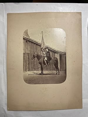 Ungarischer Magnat in Ornat im Sattel eines Pferdes mit Fahne. Fotografie um 1865.