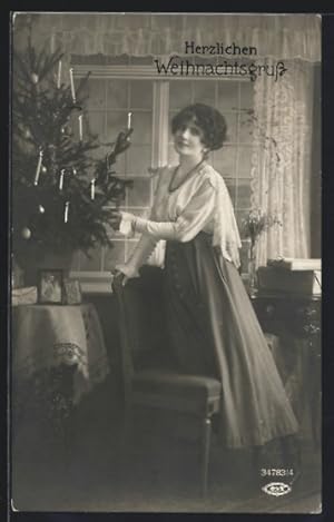 Bild des Verkufers fr Foto-Ansichtskarte BNK 34783 /4: Junge Dame steht neben dem Weihnachtsbaum, Herzlichen Weihnachtsgruss zum Verkauf von Bartko-Reher