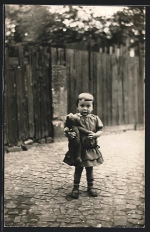 Foto-Ansichtskarte Kleines Mädchen mit Teddy im Arm