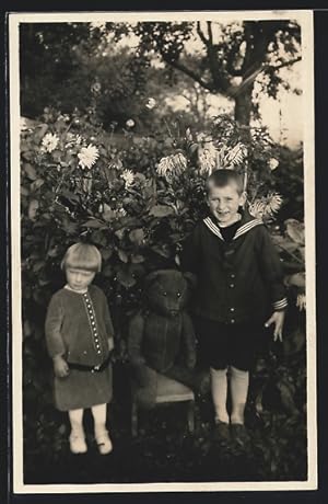 Ansichtskarte Geschwisterpaar mit grossem Teddy im Garten