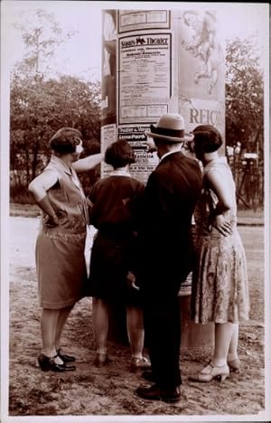 Foto Ansichtskarte / Postkarte Mann und Frauen vor einer Litfaßsäule