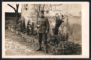 Foto-Ansichtskarte Soldat in Uniform vor einem Wohnhaus