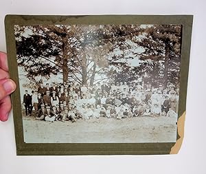 [photograph] Large gathering of people with violin and accordion in the woods