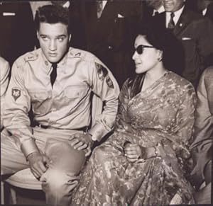 Elvis Presley in military uniform sitting next to an Indian Brahman woman. Original photograph.