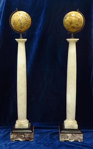 A pair of decorative globes on alabaster and marble column stands.