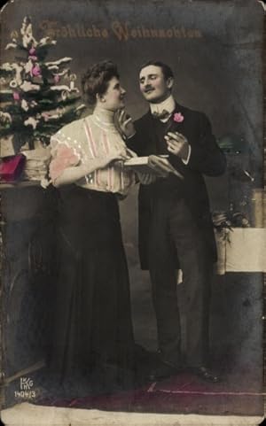 Ansichtskarte / Postkarte Glückwunsch Weihnachten, Paar am Tannenbaum