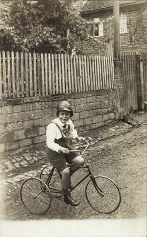 Foto Ansichtskarte / Postkarte Kind fährt Dreirad, Portrait, Straße, Zaun