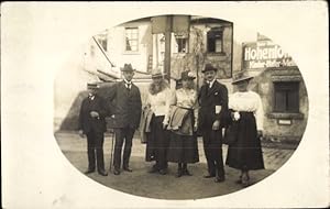 Foto Ansichtskarte / Postkarte Männer und Frauen mit Hüten vor einem Geschäft