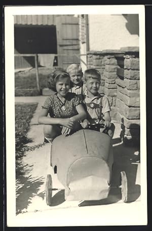 Ansichtskarte Kinder in einem Spielzeug-Auto im Garten