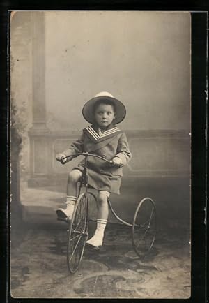Foto-Ansichtskarte Kind im Matrosenanzug auf einem Dreirad