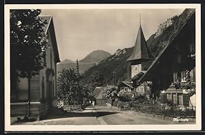 Ansichtskarte Meiringen, Strassenpartie mit Häuser und Kirchturm, Blick auf Berge