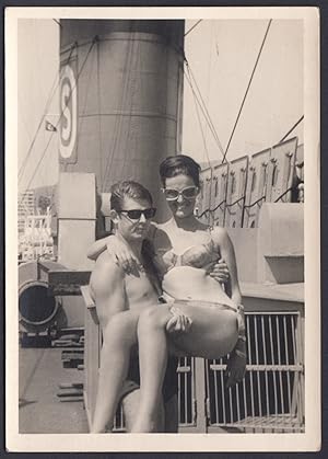 Uomo tiene in braccio donna in costume su nave, 1960 Fotografia vintage