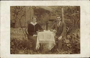 Foto Ansichtskarte / Postkarte Mann und Frau an einem Tisch im Garten, Portrait