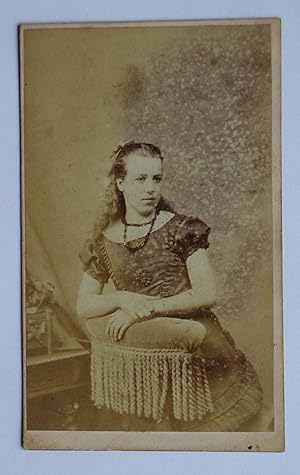 Bild des Verkufers fr Carte De Visite Photograph. Portrait of a Young Woman Standing Behind a Chair. zum Verkauf von N. G. Lawrie Books