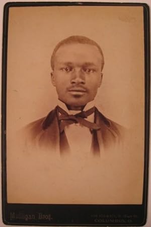 Upper body portrait of a Black man in suit with wing collar and bow tie